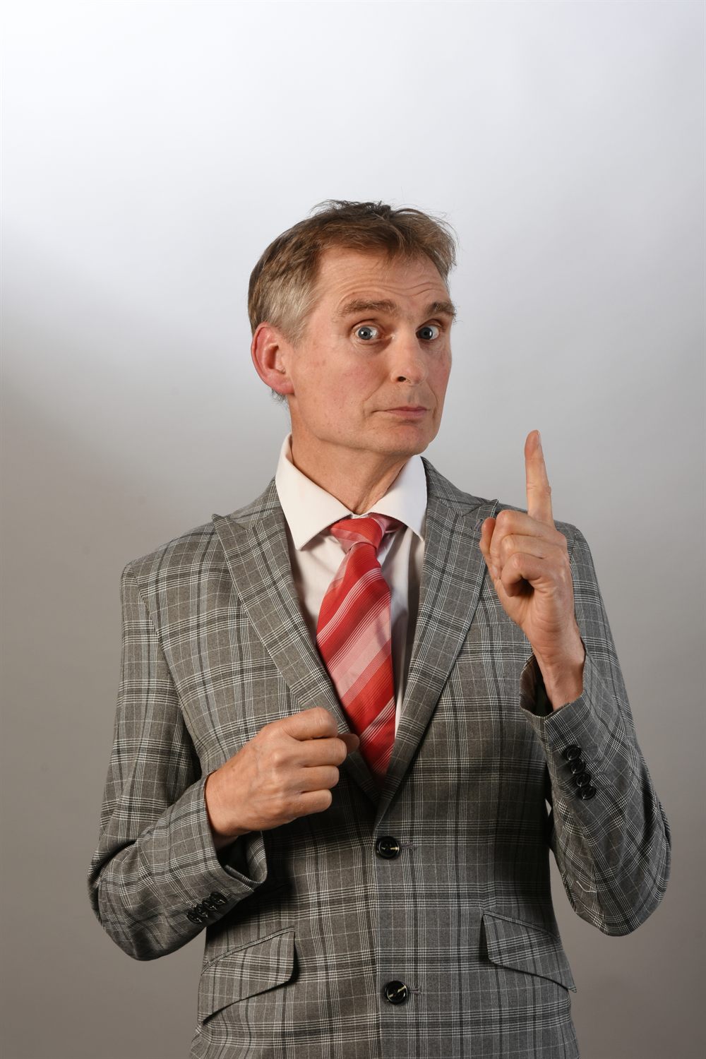 Detlef Winterberg — Comedian, mit erhobenem Zeigefinger im karierten Anzug